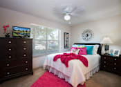 Thumbnail 10 of 14 - a bedroom with a bed, a dresser, and a ceiling fan
