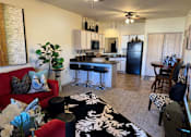 Thumbnail 6 of 21 - A living room with a red couch and a black and white rug.