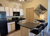 Thumbnail 9 of 21 - A kitchen with black appliances and white cabinets.