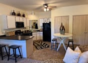 Thumbnail 12 of 21 - A kitchen with a black refrigerator and a black counter top.