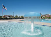 Thumbnail 1 of 21 - A blue water fountain in the middle of a pool.