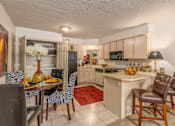 Thumbnail 2 of 11 - a kitchen and dining room with a table and chairs