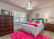 Thumbnail 3 of 11 - a bedroom with a bed and a ceiling fan