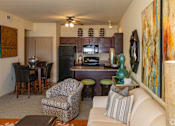 Thumbnail 15 of 21 - A living room with a couch, chair, and a painting on the wall.