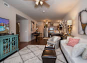 Thumbnail 3 of 13 - A living room with a white couch and a television.