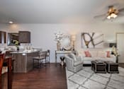 Thumbnail 4 of 14 - A modern living room with a kitchen area in the background.
