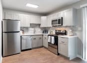 Thumbnail 1 of 18 - Kitchen with stainless steel appliances and shaker-style cabinets