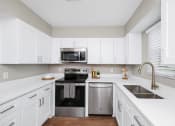 Thumbnail 1 of 16 - Kitchen with shaker style cabinets and stainless steel appliances