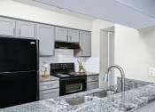 Thumbnail 1 of 17 - Kitchen with granite counter tops and black appliances