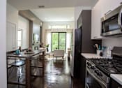 Thumbnail 12 of 14 - A kitchen with a stove top oven and a refrigerator.
