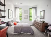 Thumbnail 3 of 14 - A bedroom with a bed, nightstand, chair, and window.
