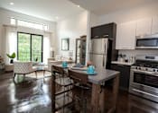 Thumbnail 11 of 14 - A modern kitchen with a dining table and chairs.