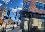 Thumbnail 13 of 14 - A brick building with a black awning and a sign that says "BRAVA" on it.