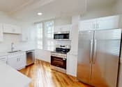 Thumbnail 90 of 96 - A kitchen with white cabinets and a stainless steel refrigerator.