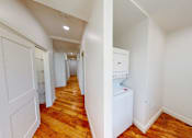 Thumbnail 88 of 96 - A hallway with a washing machine in the corner.