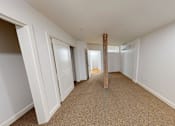 Thumbnail 81 of 96 - A long hallway with white walls and carpeted floor.