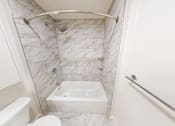 Thumbnail 96 of 96 - A white bathroom with a tub, toilet, and shower.