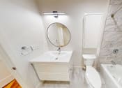 Thumbnail 83 of 96 - A white bathroom with a marble tile shower.