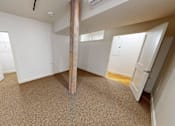 Thumbnail 82 of 96 - A room with a carpeted floor and a large pillar in the middle.