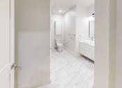 Thumbnail 94 of 96 - A white bathroom with a toilet, sink, and mirror.