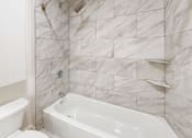 Thumbnail 95 of 96 - A white bathroom with a tub and toilet.