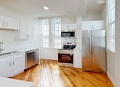 Thumbnail 79 of 96 - A modern kitchen with wooden floors and stainless steel appliances.