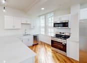 Thumbnail 89 of 96 - A kitchen with white cabinets and a white counter top.