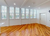 Thumbnail 91 of 96 - A room with wooden floors and large windows.