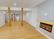 Thumbnail 55 of 96 - A room with a fireplace and wooden floors.