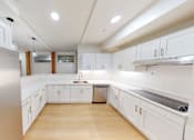 Thumbnail 49 of 96 - A modern kitchen with white cabinets and a stainless steel refrigerator.