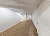 Thumbnail 59 of 96 - A long hallway with white walls and carpeted floor.