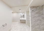 Thumbnail 46 of 96 - A white bathroom with a marble tile shower.