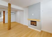 Thumbnail 51 of 96 - A room with a fireplace and wooden floors.