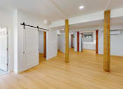 Thumbnail 58 of 96 - A room with wooden floors and white walls with a blue door.