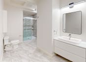 Thumbnail 72 of 96 - A bathroom with a toilet, sink, and mirror.