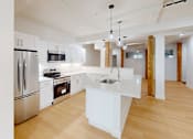 Thumbnail 62 of 96 - A modern kitchen with wooden floors and stainless steel appliances.