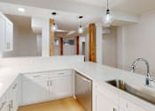 Thumbnail 69 of 96 - A kitchen with white cabinets and a stainless steel sink.