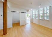 Thumbnail 70 of 96 - A room with wooden floors and a large window with blinds.
