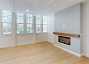Thumbnail 64 of 96 - A living room with a fireplace and large windows.