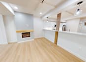 Thumbnail 41 of 96 - A room with a fireplace and wooden floors.