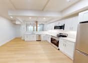 Thumbnail 25 of 96 - A kitchen with white cabinets and stainless steel appliances.