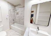 Thumbnail 30 of 96 - A white toilet sits next to a white sink in a bathroom.