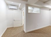Thumbnail 31 of 96 - A room with a carpeted floor and a door leading to another room.