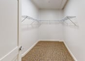 Thumbnail 35 of 96 - A white hallway with a carpeted floor and a coat rack.