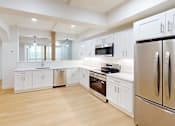 Thumbnail 42 of 96 - A modern kitchen with white cabinets and stainless steel appliances.