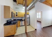 Thumbnail 3 of 12 - A kitchen with wooden cabinets and a stainless steel refrigerator.