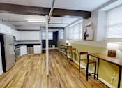 Thumbnail 6 of 12 - A kitchen with wooden floors and a bar area.