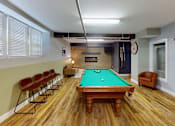 Thumbnail 7 of 12 - A pool table is surrounded by eight chairs in a room.