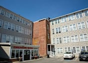 Thumbnail 11 of 12 - A brick building with a sign that says Emerson Shoe Lofts.