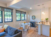 Thumbnail 36 of 53 - A living room with a grey couch and a white table.